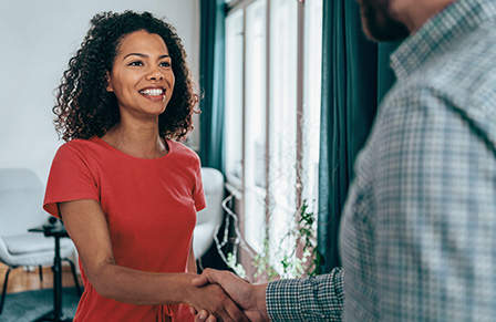 Businessman and businesswoman shaking hands and smiling